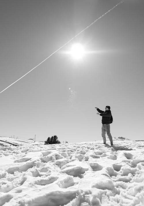 Sun Glowing over a Man Standing on Snow