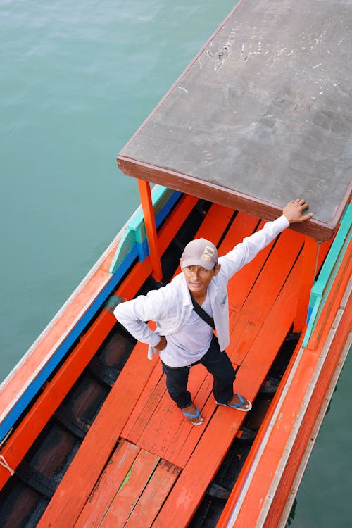 Man Stands on Red Boat
