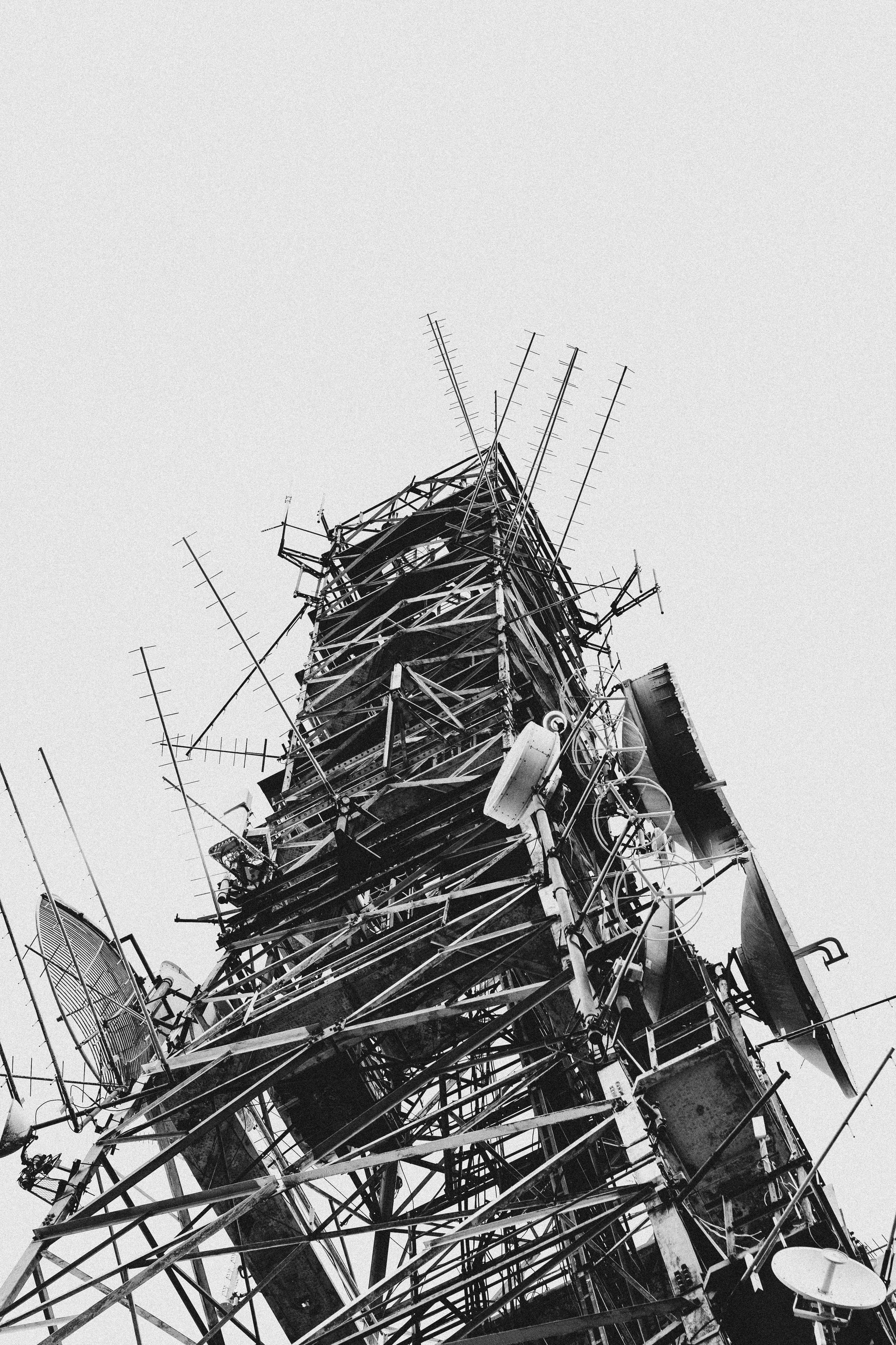 A monochromatic view of a towering radio communications structure capturing various antennas.