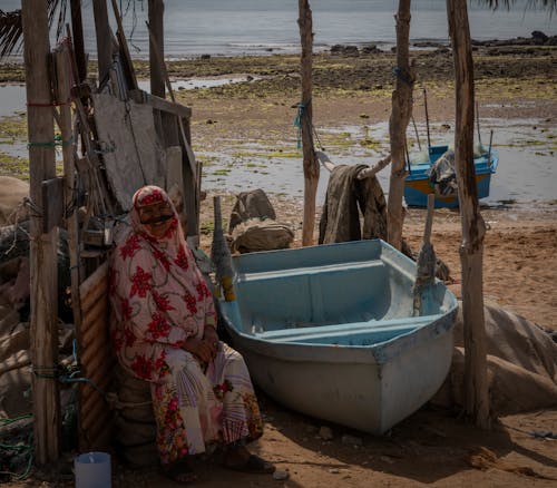 Man Sitting By a Boat