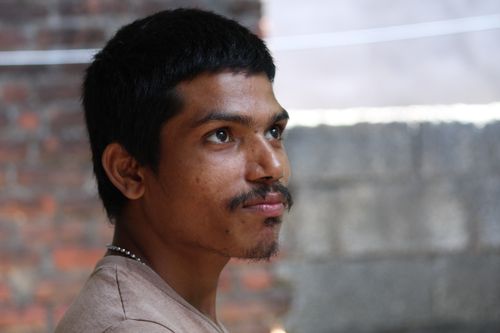 Free Profile portrait of a young man with a mustache, looking away contemplatively outdoors. Stock Photo
