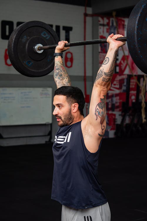 A Tattooed Man Training at the Gym 