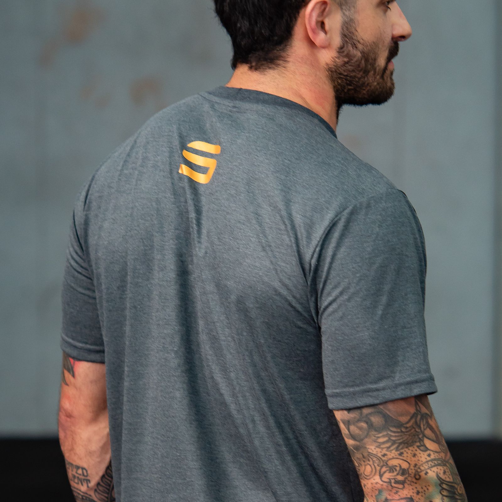 Athlete wearing a gray performance shirt in a gym