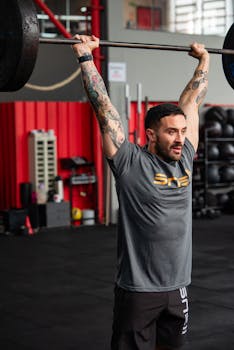 A muscular man engaged in weightlifting at an indoor gym setting.
