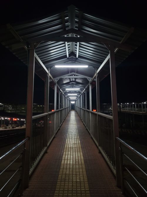 Free Symmetrical view of a lit urban footbridge at night, creating a futuristic feel. Stock Photo