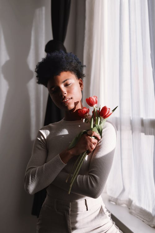 Základová fotografie zdarma na téma bílý svetr, černoška, červené tulipány