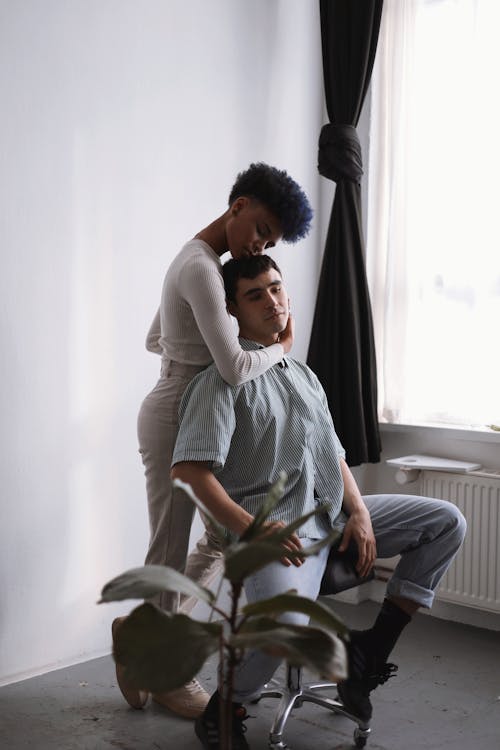 Woman Embracing a Man Sitting on a Chair