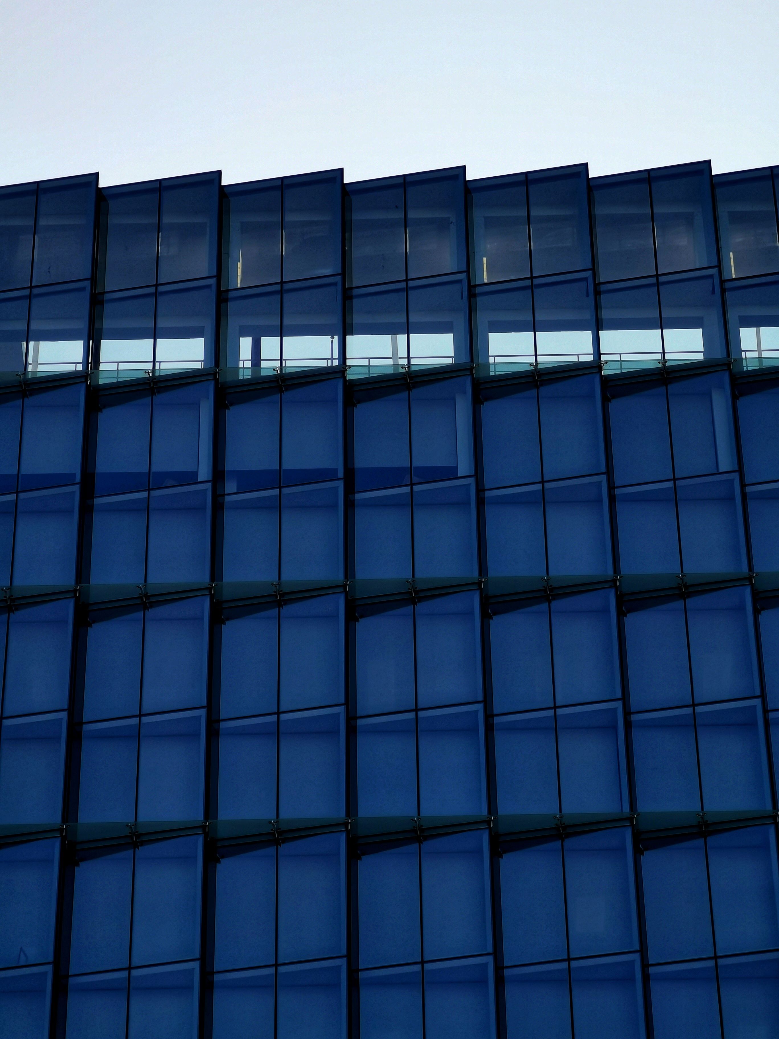 A blue building with windows and a blue sky · Free Stock Photo