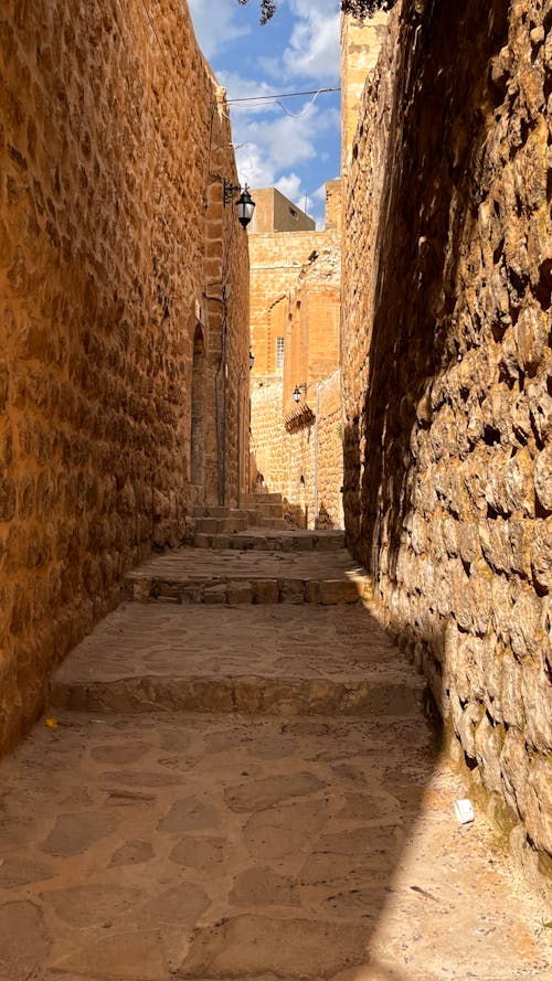 A narrow alleyway with stone walls and stairs