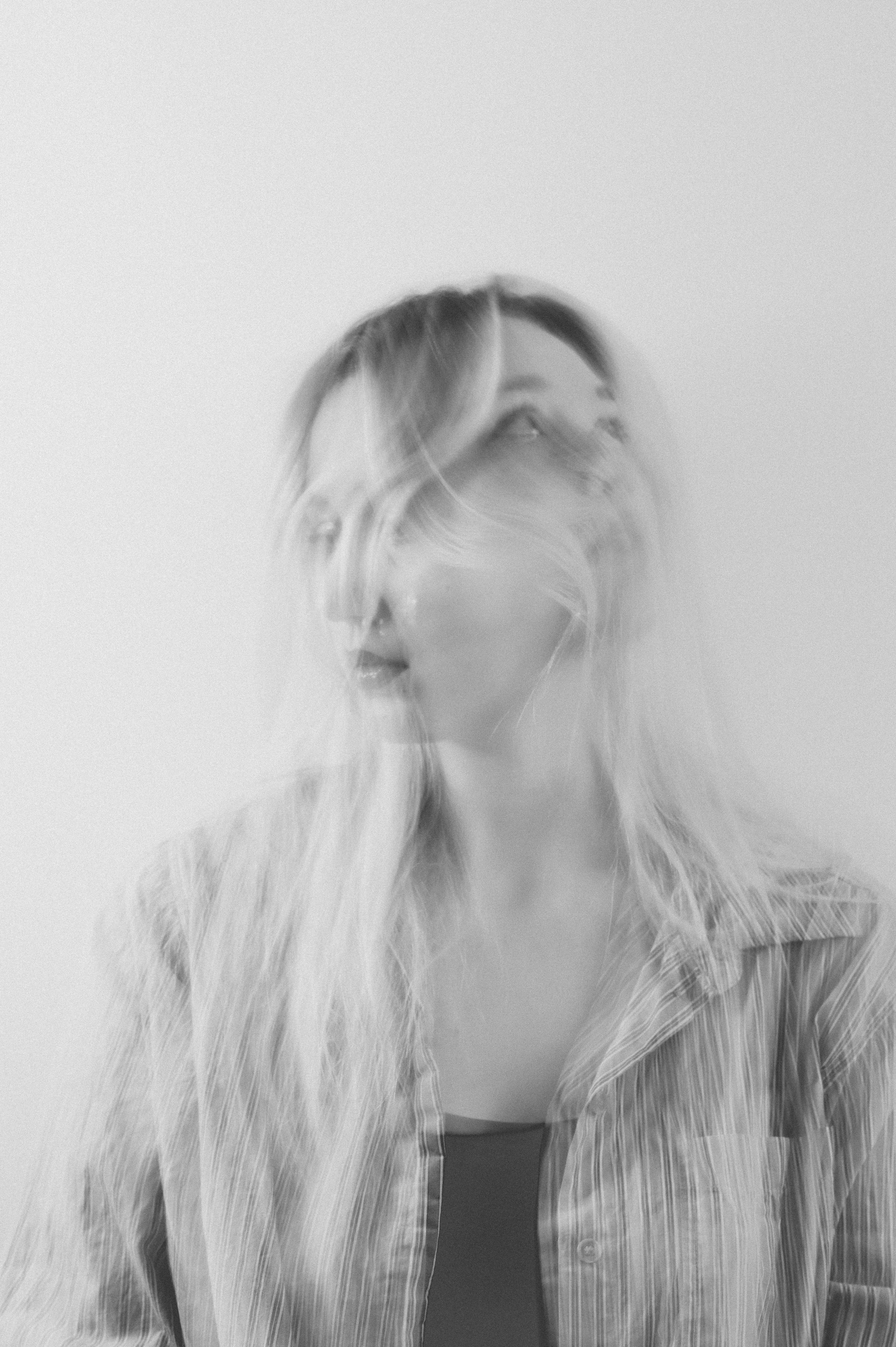 Ethereal black and white double exposure portrait of a woman creating a dreamlike effect.