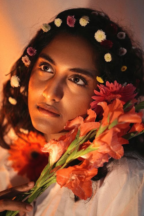 Young Woman with Flowers in Her Hair and Holding Gladiolus Flowers