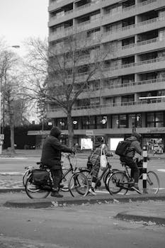 Black and white photo of cyclists riding through Eindhoven, Netherlands.