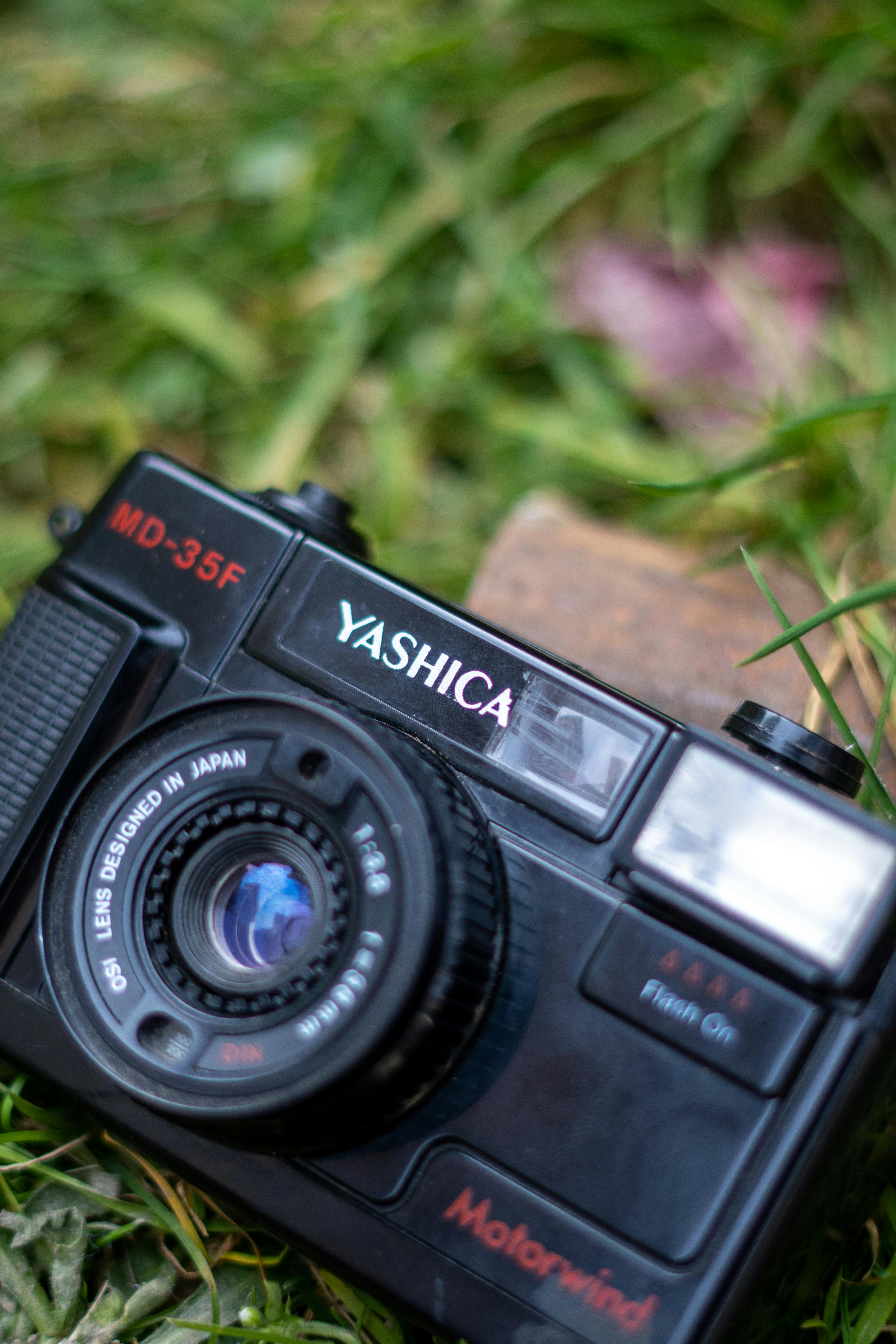 Close-up of a Yashica MD-35F camera on grass, showcasing its retro design.