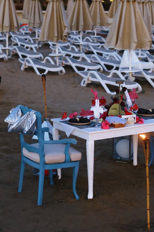 A table with chairs and a candle on the beach
