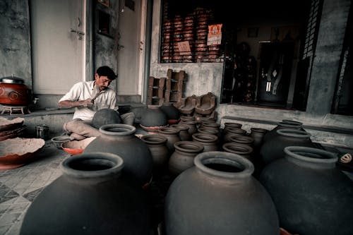 A Man Sitting in a Room with Pots