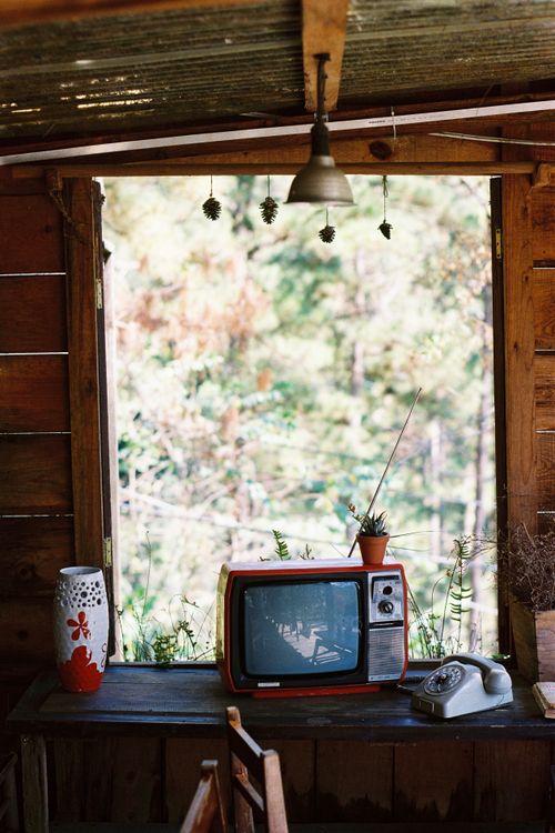 Free Cozy room with vintage TV and rotary phone by a window, reflecting a nostalgic ambiance. Stock Photo