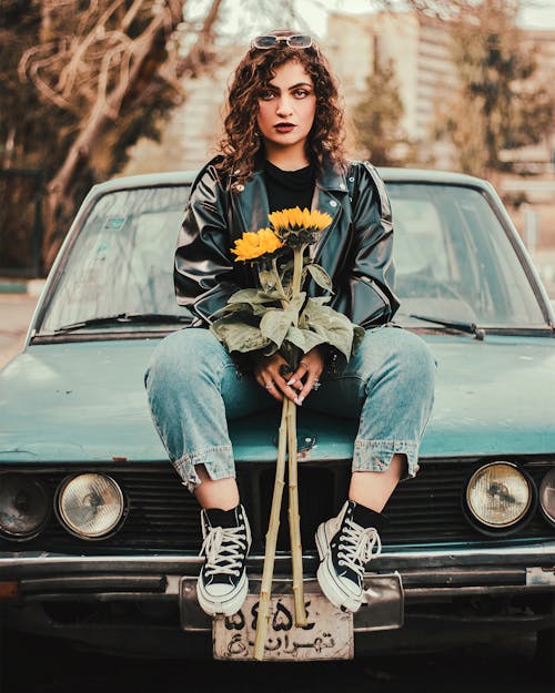 Woman with Sunflowers, Sitting on a Vintage Car