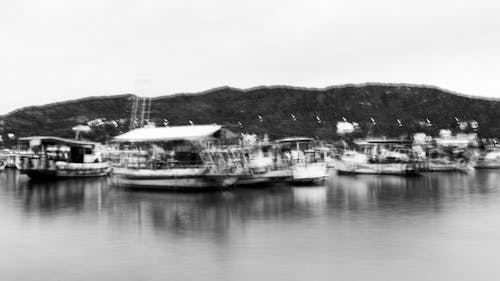 A black and white photo of boats docked in the water