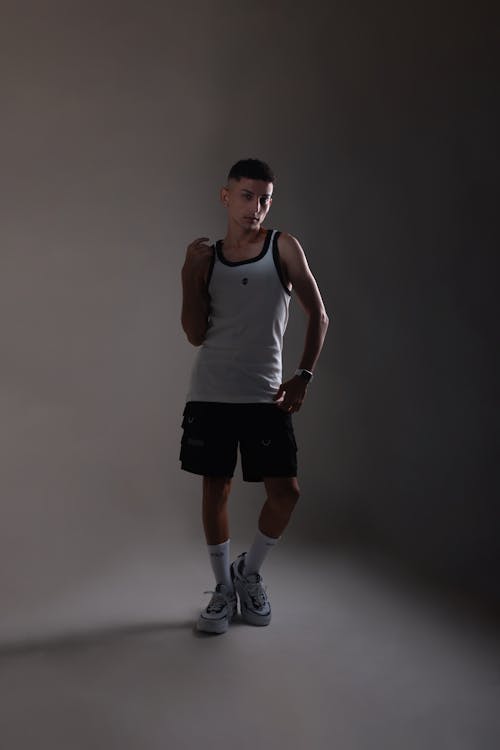 A man in a tank top and shorts posing for a photo