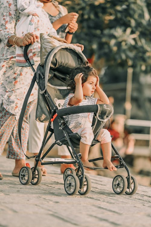 A woman pushing a stroller with a child in it