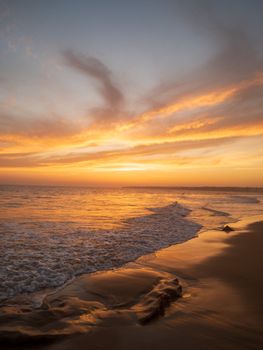 Captivating sunset over the ocean with dramatic clouds and tranquil waves.