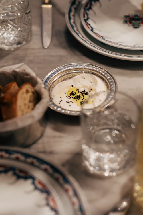 Free A beautifully arranged dining table setting with ornate plates and a dish of dip, exuding elegance. Stock Photo