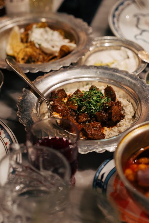 Free A sumptuous display of Mediterranean dishes served elegantly on silver platters, showcasing rich culinary traditions. Stock Photo