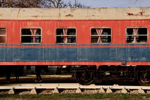 Free A close-up view of a vintage red and blue abandoned train car with windows. Stock Photo
