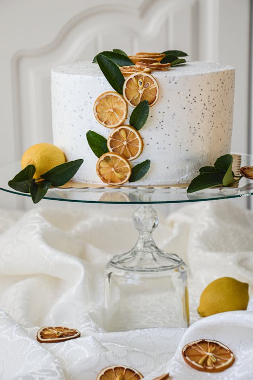 Fruit Sliecs and Lemons and Leaves around Cake on Plate