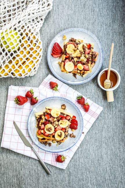 Satisfying morning meal of waffles with bananas and strawberries.