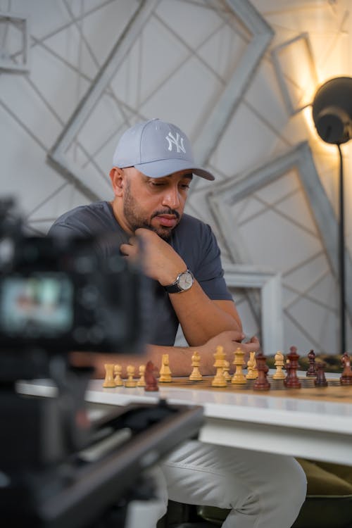 Man in Cap Sitting and Playing Chess