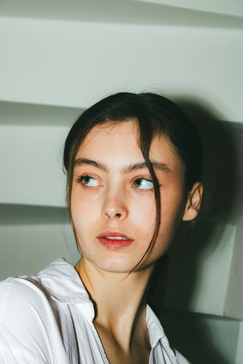 Free Elegant young woman in minimalist indoor setting, looking thoughtful. Stock Photo