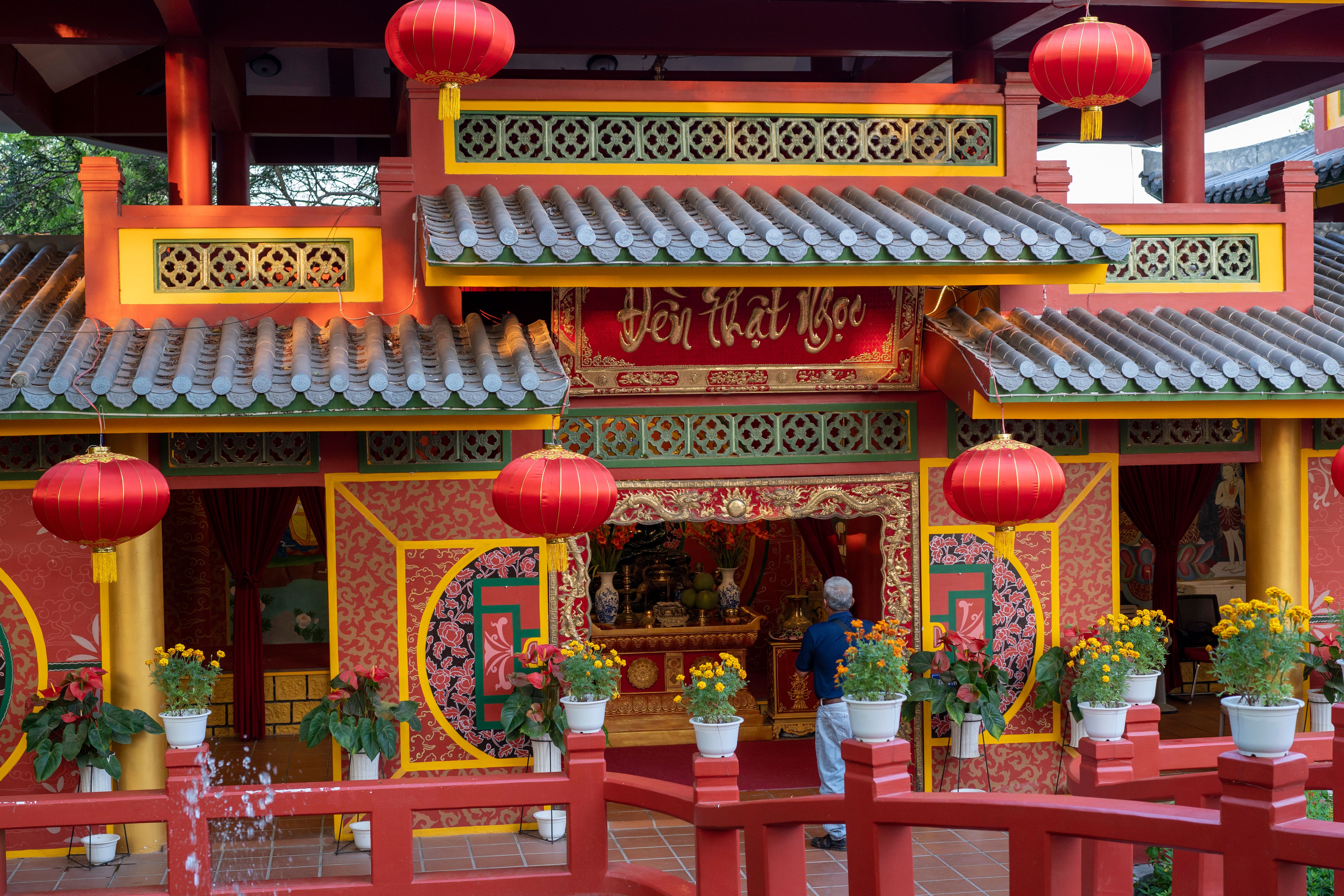 Decorative Asian temple entrance with red lanterns and vibrant colors, symbolizing spirituality.