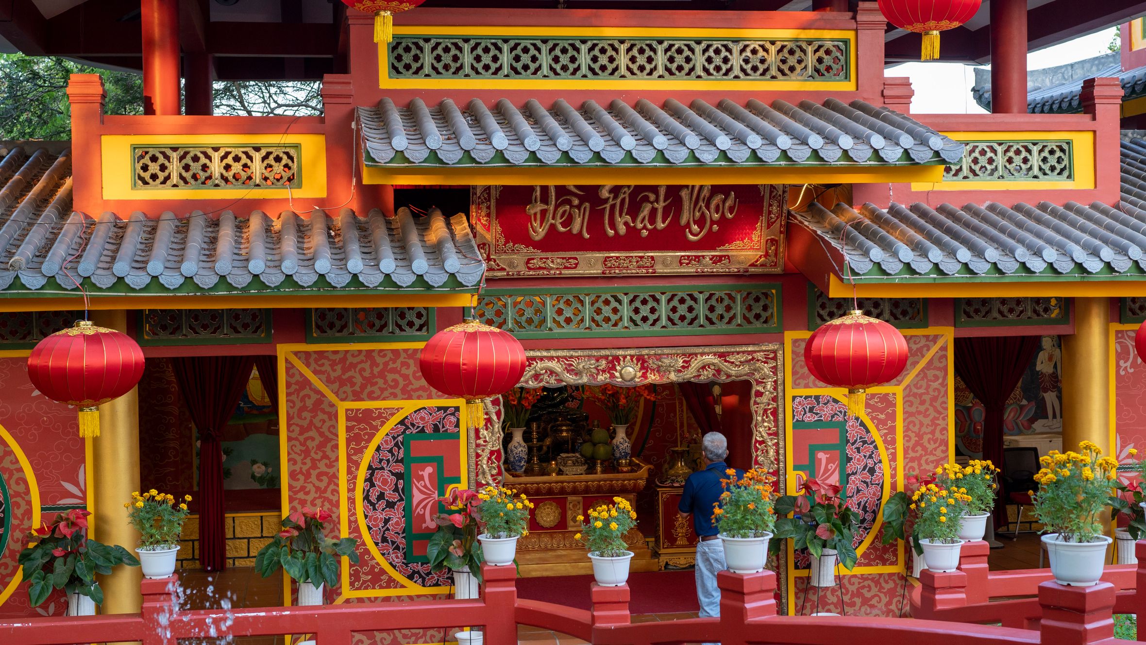 Decorative Asian temple entrance with red lanterns and vibrant colors, symbolizing spirituality.