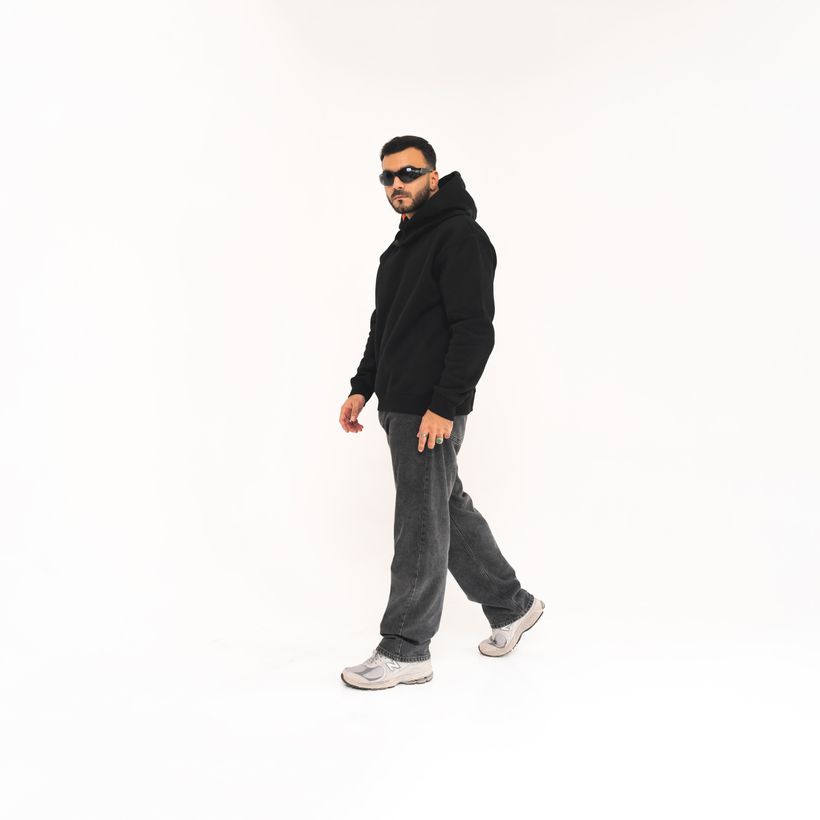 Oversized hooded fleece worn in a studio, front. Photo by Khalid Joe on Pexels