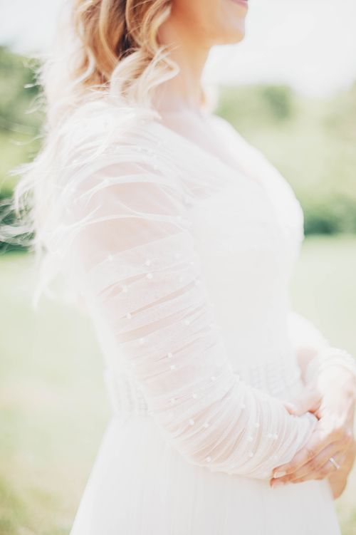 Free A blonde bride in an elegant white wedding dress posing outdoors in natural light. Stock Photo