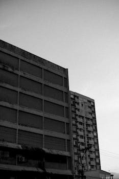 一张城市高层建筑的黑白照片，在晴朗天空下显得格外戏剧性