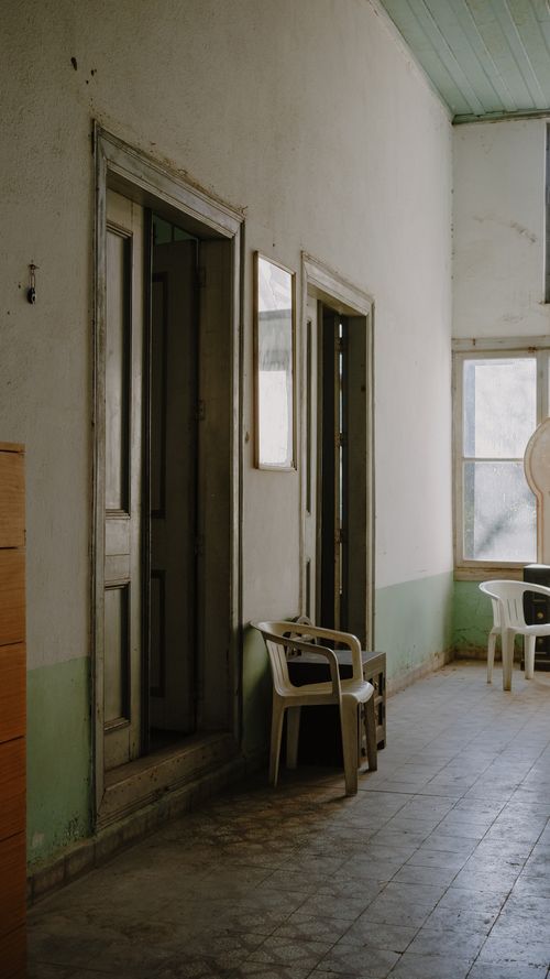 Free Explore the textured, rustic hallway of an aged apartment with open doors and vintage charm. Stock Photo