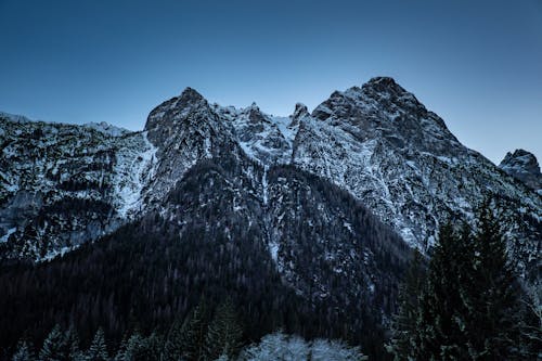 Scenic View of Rocky, Snowcapped Mountains under Blue Sky 