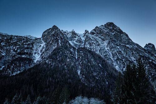 Free Stunning view of a snowcapped mountain range under a clear blue sky during twilight. Stock Photo