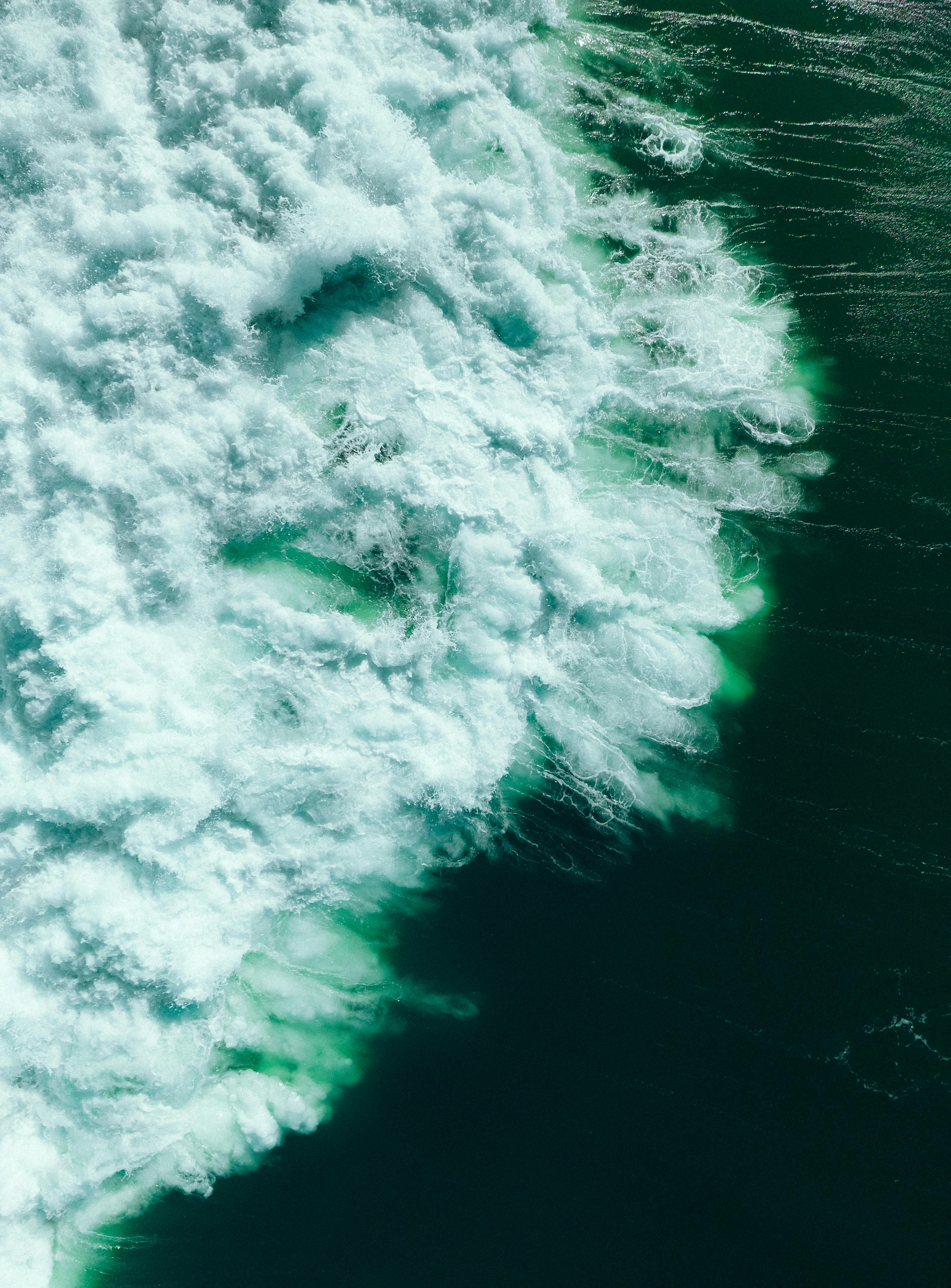 A dynamic aerial capture of ocean waves crashing with rich textures and colors.