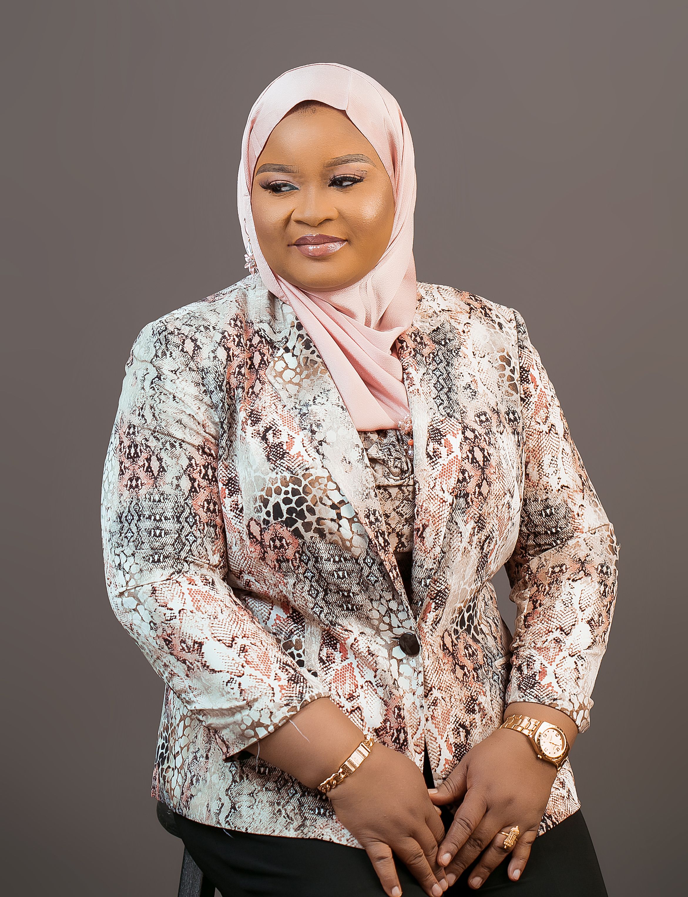 Portrait of a confident woman in a snake print blazer and hijab, exuding elegance.