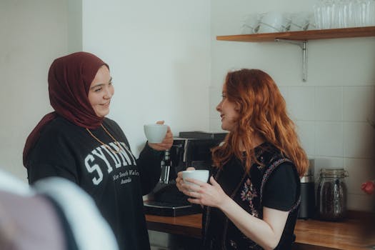 Casual conversation between two women sharing coffee indoors. A cozy and friendly atmosphere.