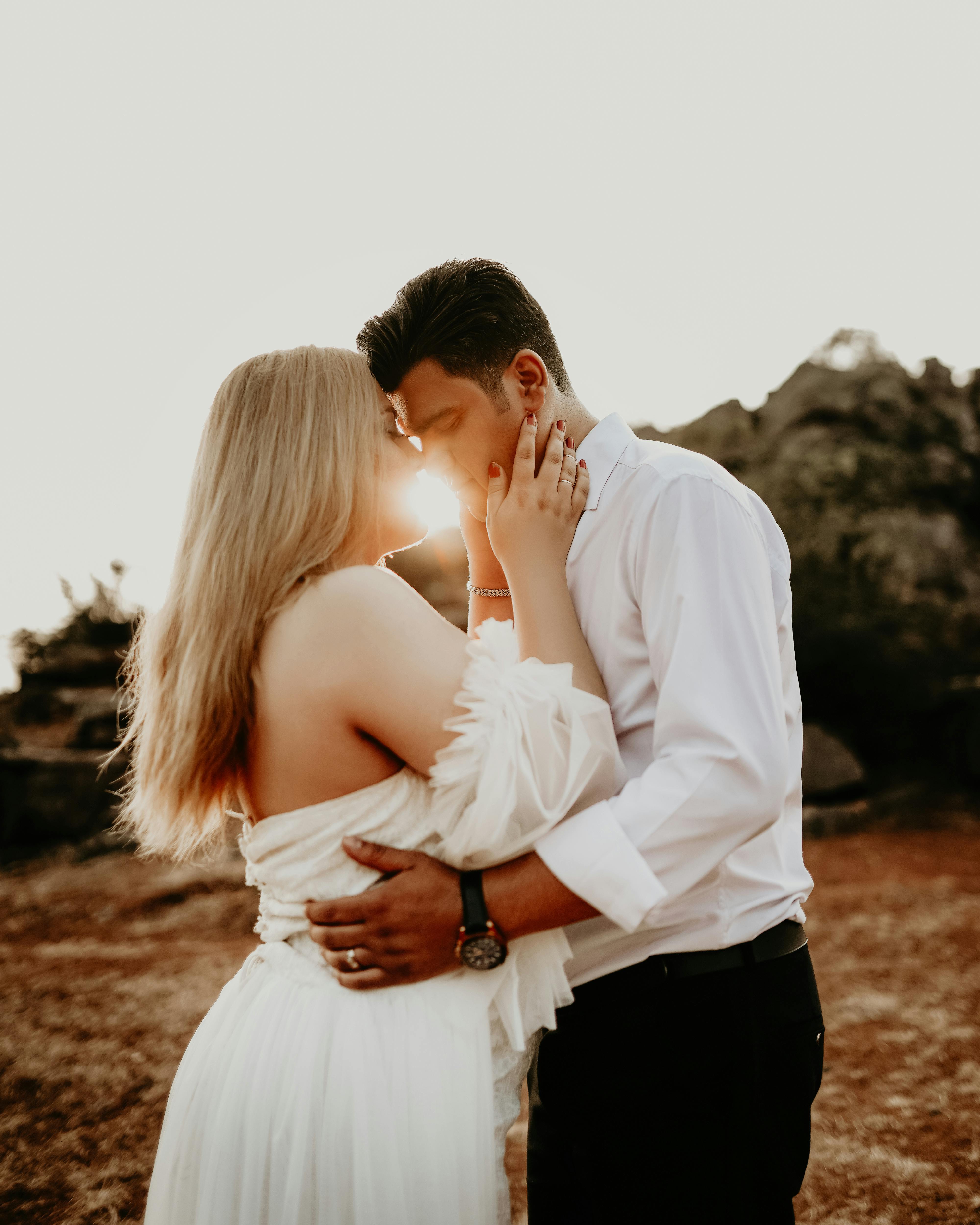 A loving couple sharing a tender moment outdoors during sunset, capturing romance and intimacy.