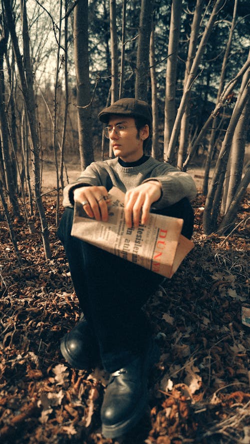 A man sitting in the woods holding a bag