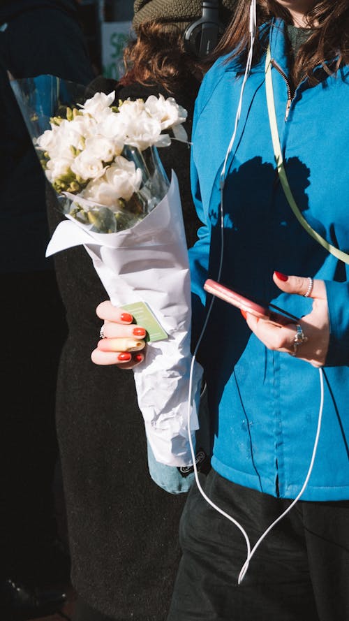 Holding a Bouquet of Flowers and a Smartphone
