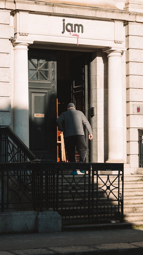 A man is walking up the steps of a building