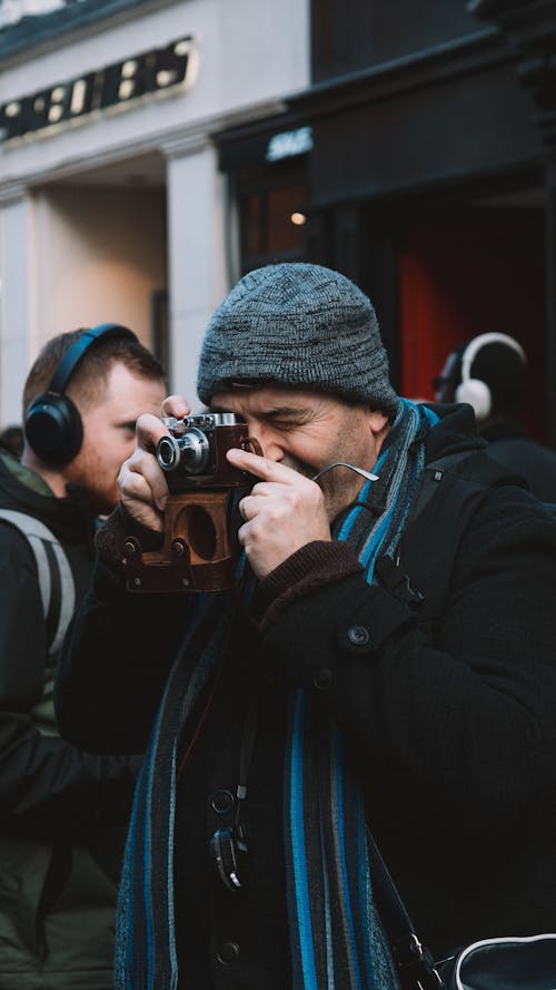 Man in Jacket Taking Pictures with Camera