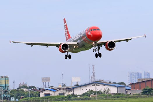 AirAsia aircraft approaching urban airport for landing.