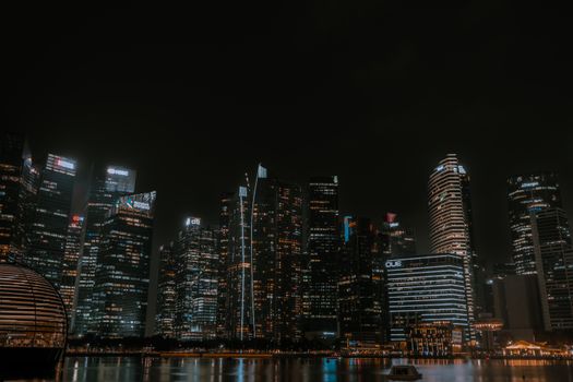 A breathtaking view of Singapore's illuminated skyline reflecting on water, captured at night.